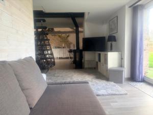 a living room with a couch and a television at Gîte de la Galimondaine in Bouguenais +3 photos