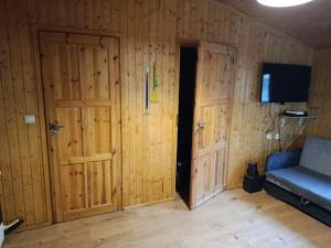 a room with two wooden doors and a couch at Domek letniskowy in Wójcin