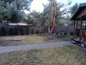 a backyard with a tree and a fence at Domek letniskowy in Wójcin +1 photo
