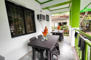 a patio with a table and chairs on a balcony at MilVir Tourist Inn El Nido near Beach in El Nido