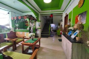 a room with green walls and a table and chairs at MilVir Tourist Inn El Nido near Beach in El Nido