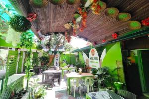 a restaurant with tables and chairs and plants at MilVir Tourist Inn El Nido near Beach in El Nido