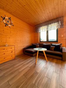 a living room with a couch and a table at Morska Melodia in Sarbinowo