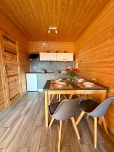 a kitchen with a table and chairs in a room at Morska Melodia in Sarbinowo