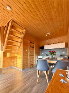 a kitchen with wooden ceilings and a wooden table and chairs at Morska Melodia in Sarbinowo