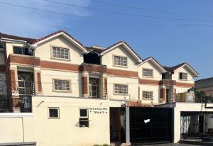a large white house with a black gate at ShowLove Luxury Apartment in Lekki Phase 1
