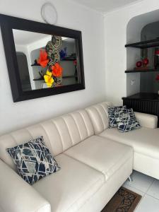 a white couch in a living room with a mirror at Casa Cortijos in Valledupar