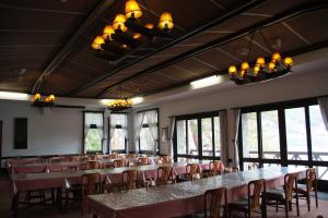 uma grande sala com mesas, cadeiras e janelas em Kawaguchiko Hotel em Fujikawaguchiko