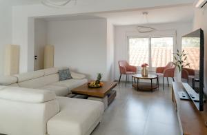 a living room with a white couch and a table at Villa Oneiron in Anavyssos