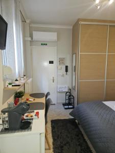 a bedroom with a bed and a desk and a room at B&M Cozy Corner in Igoumenitsa