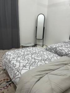 a bedroom with a bed and two mirrors on the wall at Elite Apartment in Nizwa