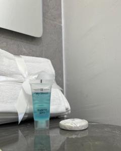 a bottle of my throat cream on a table next to a bed at Elite Apartment in Nizwa +4 photos