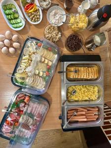 a table with trays of different types of food at Noclegi Kołek in Pogórze