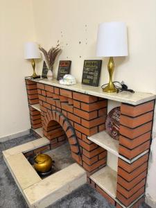 a brick fireplace with a lamp on top of it at Room In Madinah in Quai