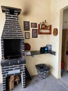 a brick fireplace in a room with a shelf at Pousada da vila in Beberibe