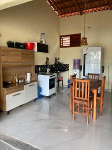 a kitchen with a table and a stove top oven at Pousada da vila in Beberibe