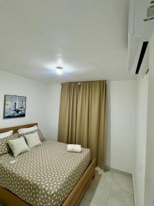 a small bedroom with a bed with a curtain at Estilo y comodidad a pasos de la playa in La Romana
