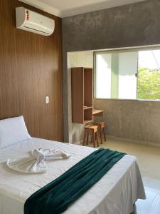 a bedroom with a bed and a window and a desk at Pousada da Samira in Andaraí