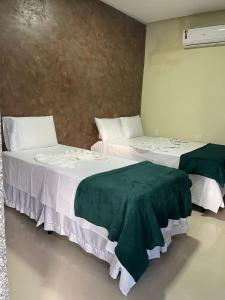 two beds sitting next to each other in a room at Pousada da Samira in Andaraí