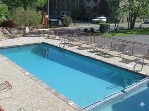 a large blue swimming pool with chairs around it at Mountain House motor Inn Downtown Gatlinburg in Gatlinburg