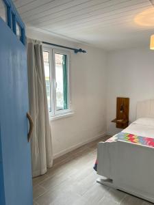 a bedroom with a bed and a window at Casa Praia do Fogo in Ribeira Quente