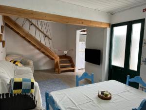 a room with a bed and a table and chairs at Casa Praia do Fogo in Ribeira Quente