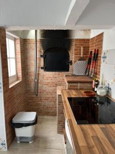 a kitchen with a counter and a brick wall at Casa Praia do Fogo in Ribeira Quente +14 photos
