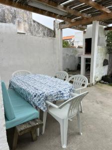 a table and chairs with a blue and white tablecloth on it at Casa Praia do Fogo in Ribeira Quente