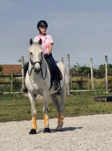ein junges Mädchen, das auf einem weißen Pferd reitet in der Unterkunft Equiliberdade in Almeirim + 34 Fotos