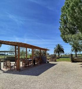ein Pavillon mit Tisch und Stühlen und einem Baum in der Unterkunft Equiliberdade in Almeirim