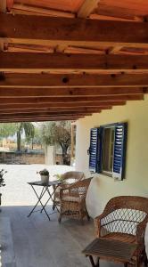 eine Terrasse mit Stühlen, einem Tisch und einem Fenster in der Unterkunft Equiliberdade in Almeirim