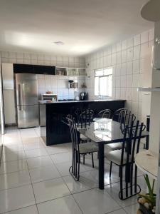 a kitchen with a table and chairs and a refrigerator at Casa privada 3 quartos próx aos canyos in Piranhas