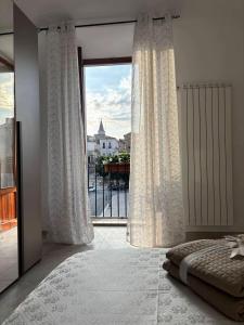 a bedroom with a large window with a view at Piazza Maggiore in Sulmona