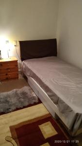 a bed in a room with a nightstand and a bed sidx sidx at 150 metres from the beach dafnes Patra in Patra