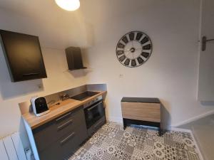 a kitchen with a sink and a clock on the wall at appartement proche gare SNCF in Tours