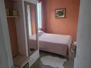a small bedroom with a bed and a mirror at appartement proche gare SNCF in Tours