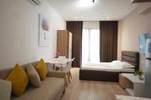 a living room with a couch and a table at Hotel Apart Odeon in Durrës