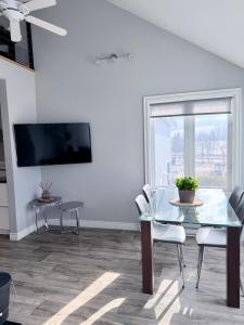 a dining room with a glass table and chairs at La Première vue in Magog-Orford