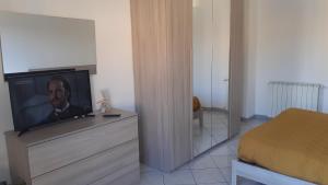 a television on a dresser in a bedroom at Casa Vacanza Pineta in Oltrona di San Mamette