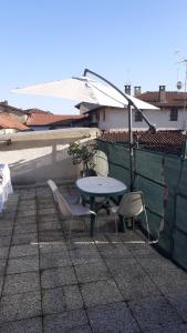 a patio with a table and chairs and an umbrella at Casa Vacanza Pineta in Oltrona di San Mamette