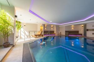 a swimming pool with blue water in a building at Kampenkliff ehemals Walter´s Hof in Kampen