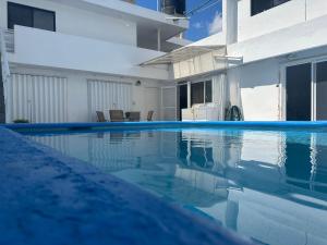 a swimming pool next to a white building at Casa Dorada in Cancún