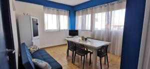 a kitchen with a table and chairs and a blue wall at Casa Vacanze Samelia in Altavilla Milicia +13 photos