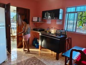 a woman is standing in a kitchen at Flat, primeiro andar, perto do Chevrolet Hall e Centro de Convenções e in Recife