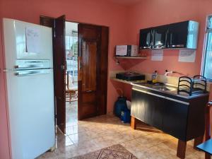 a kitchen with a white refrigerator and a sink at Flat, primeiro andar, perto do Chevrolet Hall e Centro de Convenções e in Recife