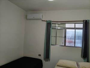 a small room with a window and a bed with a black mattress at Flat, primeiro andar, perto do Chevrolet Hall e Centro de Convenções e in Recife