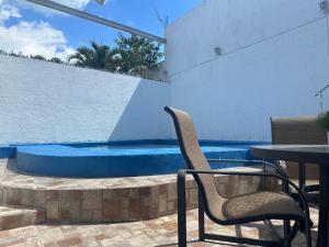a table and two chairs next to a swimming pool at Casa Dorada in Cancún