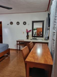 a dining room with a wooden table and a mirror at Casa de Descanso Lolha Bacalar in Bacalar +16 photos