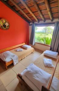 a bedroom with two beds and a large window at Pousada Mirante Serra Verde in Carrancas +42 photos