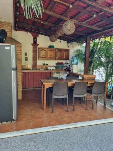 a kitchen with a wooden table and chairs in a kitchen at Casa de Descanso Lolha Bacalar in Bacalar